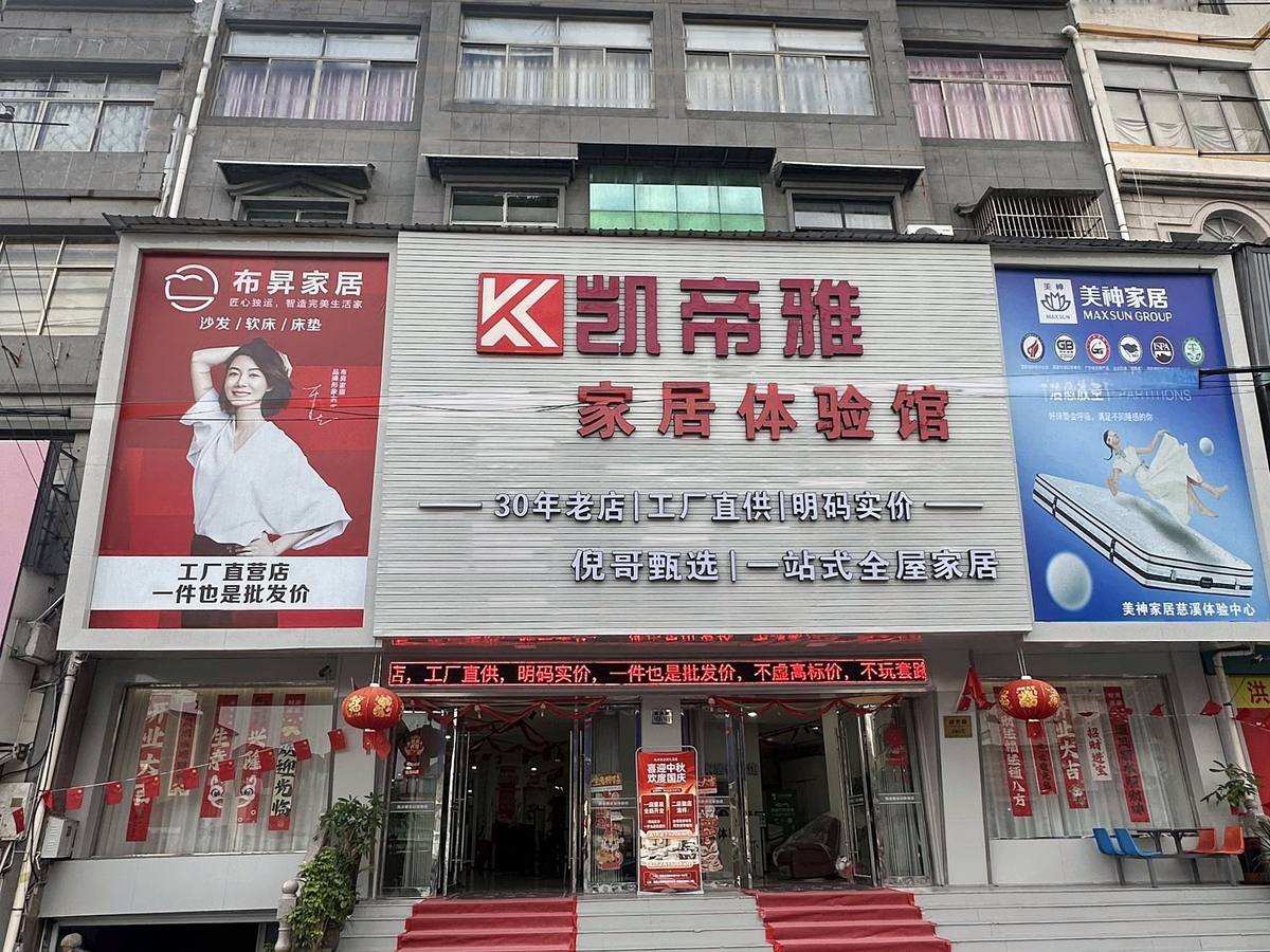 凯帝雅家居体验馆门头：红色K字标和“凯帝雅 家居体验馆”招牌，招牌上写着“30年老店｜工厂直供｜明码实价”，两侧是布昇家居和美神家居的广告